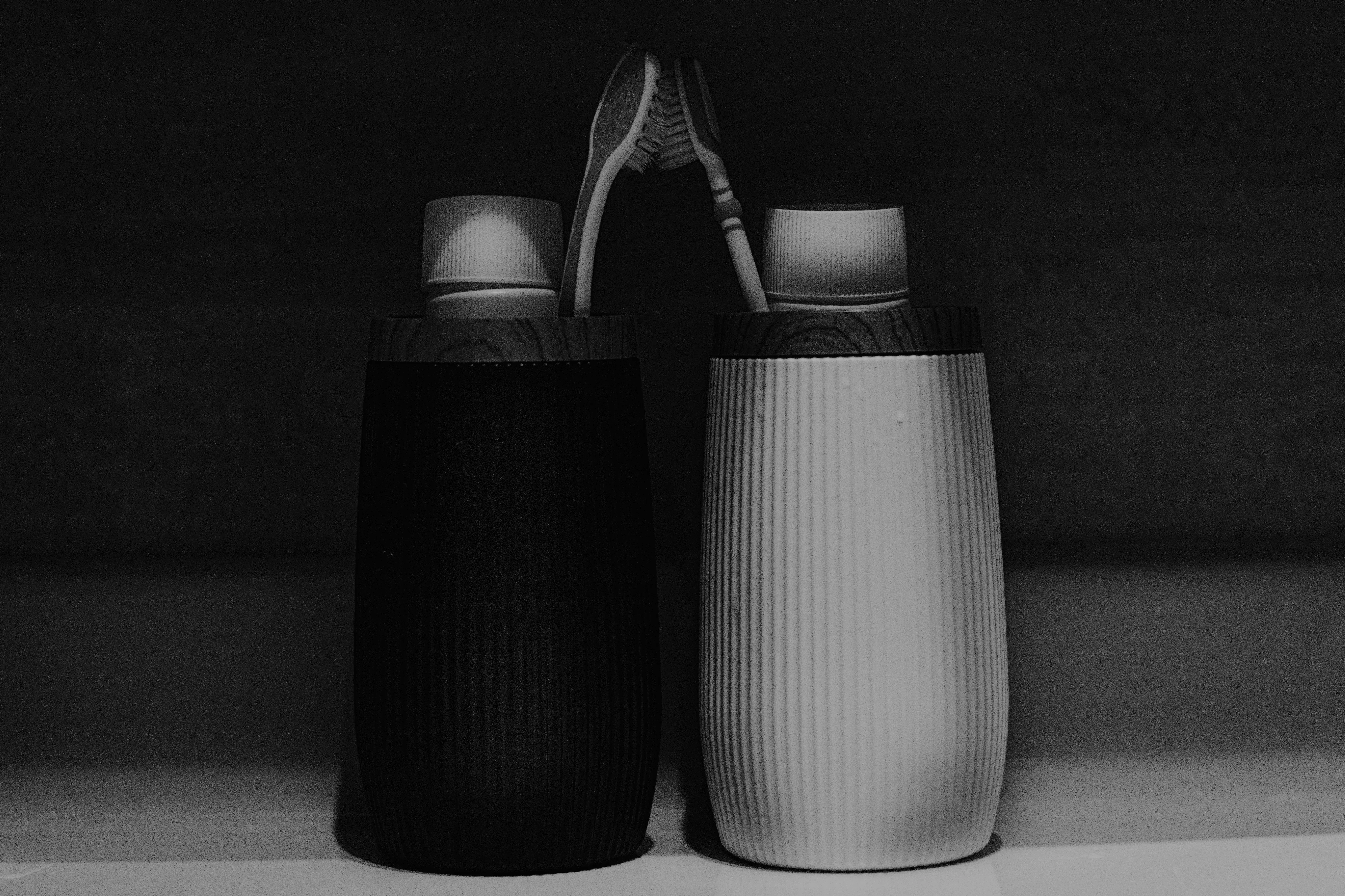 Deux brosses à dents se touchant dans l'ombre